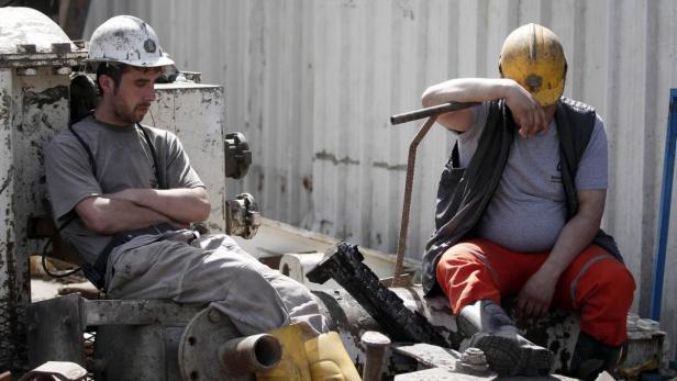Zwei Bauarbeiter machen eine Pause auf einer Baustelle.