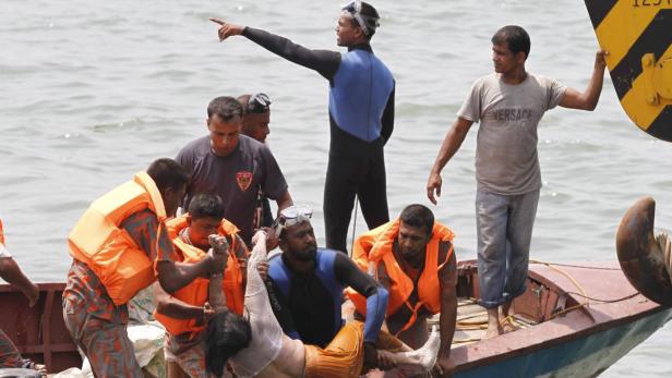Rettungskräfte bergen eine Person aus dem Wasser in ein Boot.