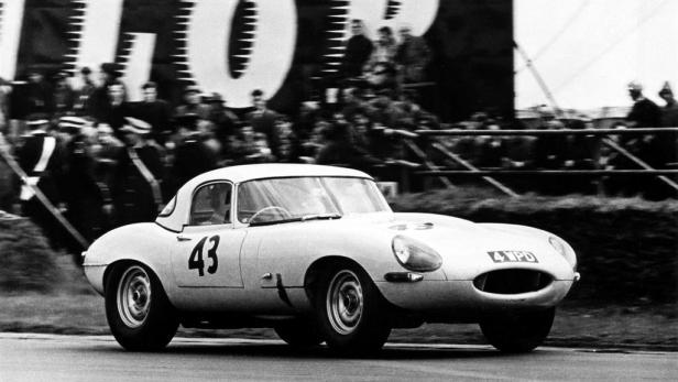 Ein weißer Jaguar E-Type mit der Nummer 43 fährt auf einer Rennstrecke.