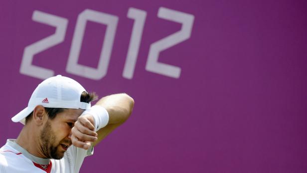 Ein Tennisspieler wischt sich den Schweiß von der Stirn vor dem Hintergrund der Zahl 2012.