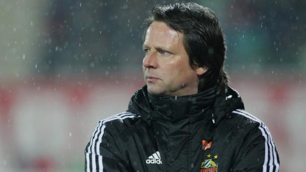 Ein Mann in einer Adidas-Jacke steht im Regen.