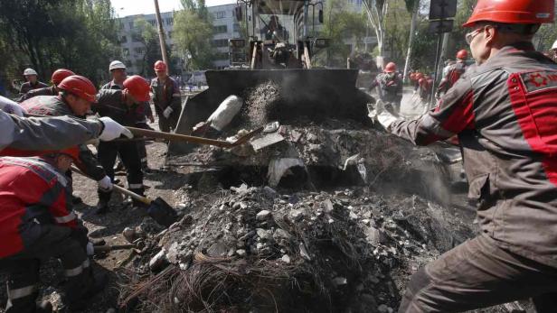 Arbeiter der Firma Metinvest,bauen die Barriakden vor dem Rathaus von Mariupol ab