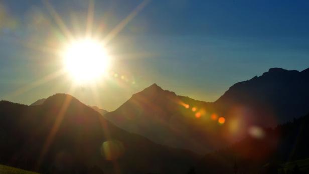 Die Sonne scheint hell über den Berggipfeln.