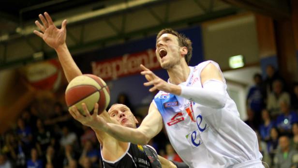 Zwei Basketballspieler kämpfen um den Ball während eines Spiels.