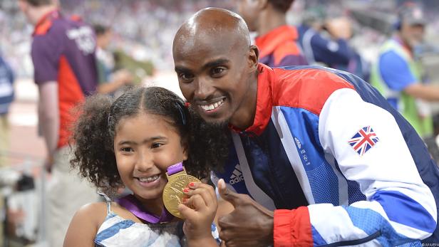 Mo Farah posiert mit einem jungen Mädchen und seiner Goldmedaille bei den Olympischen Spielen.