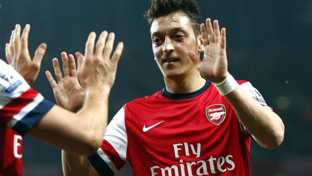 Mesut Özil, im Trikot von Arsenal, gibt einem Mitspieler ein High-Five.