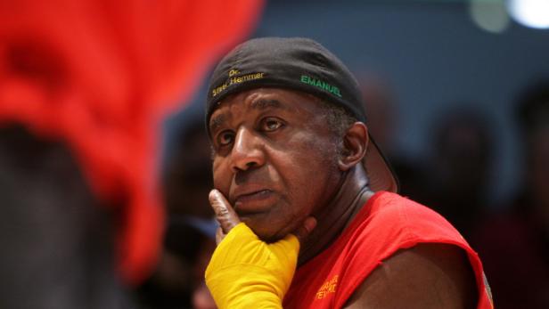 Ein Mann mit gelben Bandagen und einer Kappe mit der Aufschrift „Emanuel“ denkt nach.