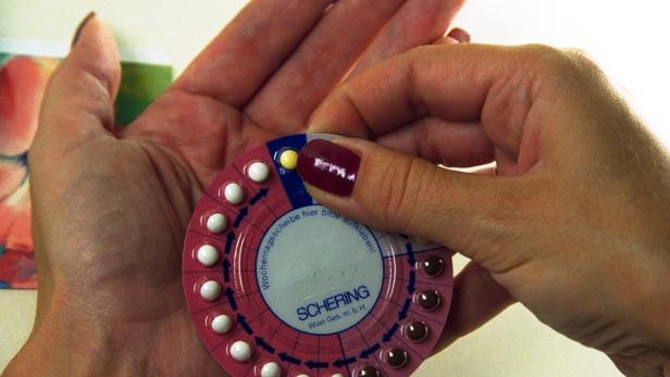 Eine Frau drückt eine Pille aus einer Schering-Antibabypillenpackung.