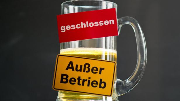 Ein Bierkrug mit Schildern, die „geschlossen“ und „Außer Betrieb“ anzeigen.