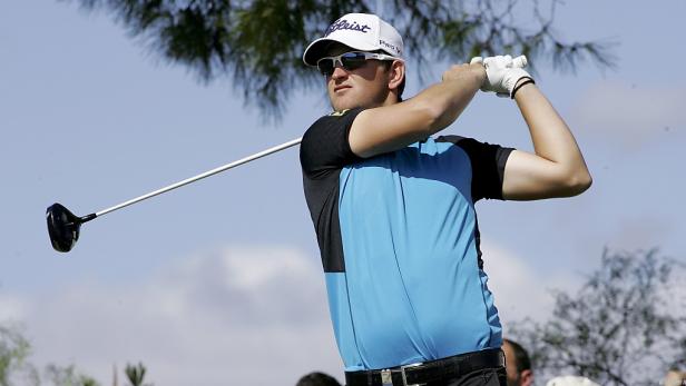 Ein Golfspieler schwingt seinen Schläger auf einem Golfplatz.