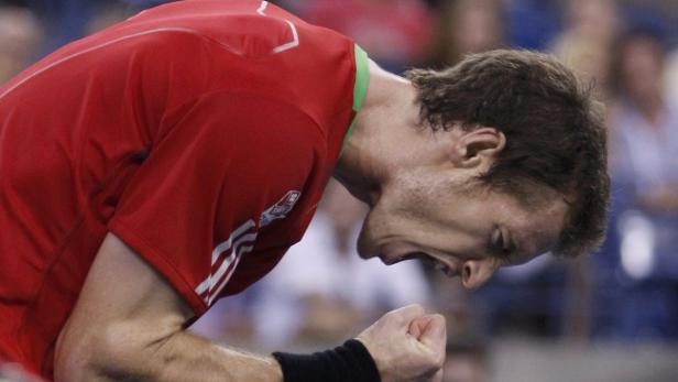 Ein Tennisspieler jubelt mit geballten Fäusten und verzerrtem Gesicht.