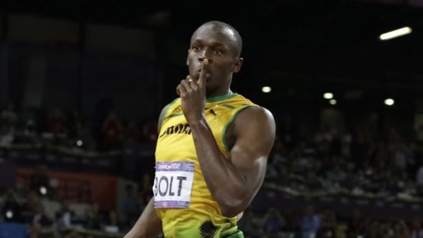 Usain Bolt legt bei einem Leichtathletikwettkampf den Finger auf die Lippen.