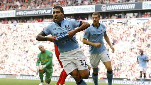 Ein Fußballspieler von Manchester City jubelt mit hochgerissenem Trikot.