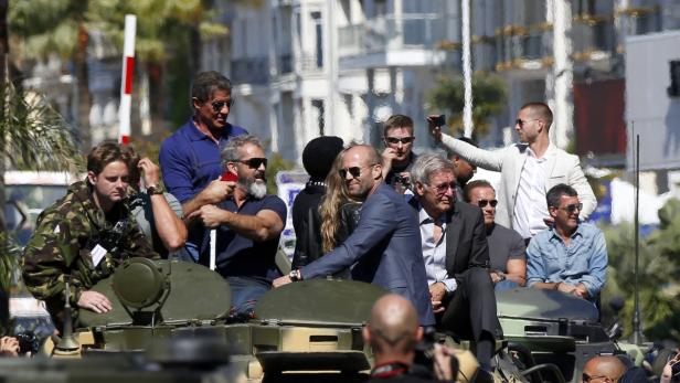 Eine Gruppe von Schauspielern, darunter Sylvester Stallone und Jason Statham, auf einem Panzer.