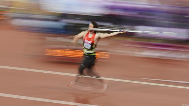 Ein Speerwerfer im roten Trikot während des Wurfs.