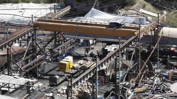 Arbeiter inspizieren eine Industrieanlage mit einem gelben Brückenkran.