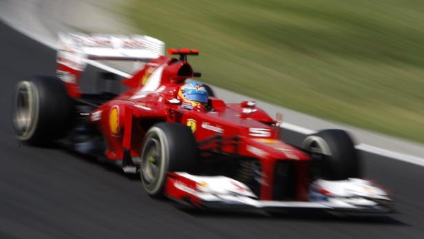 Ein roter Ferrari-Rennwagen rast auf einer Rennstrecke.