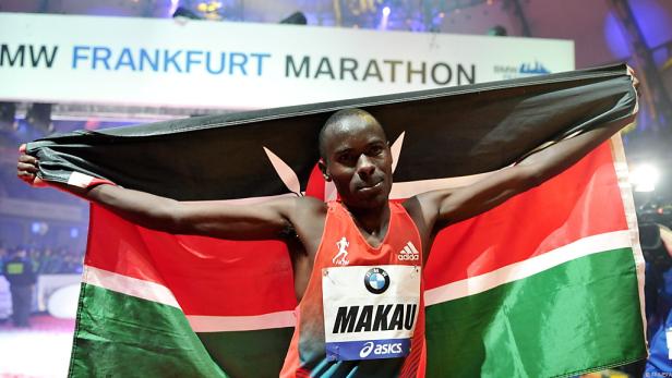 Ein Läufer, Makau, hält eine kenianische Flagge beim Frankfurt Marathon hoch.