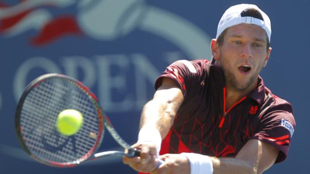 Ein Tennisspieler schlägt bei den US Open einen Ball.