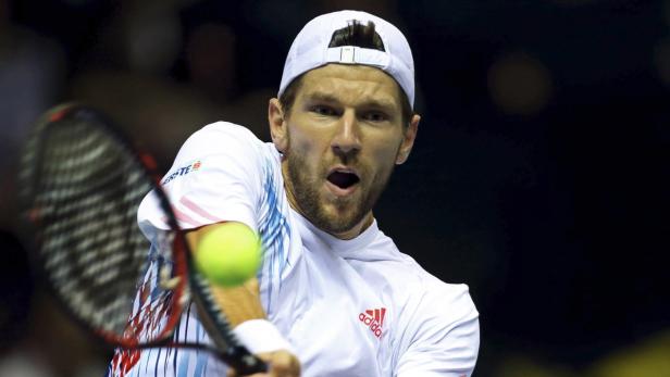 Ein Tennisspieler schlägt einen Ball mit seinem Schläger.