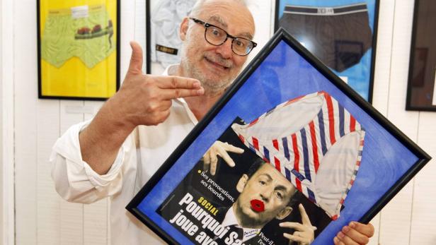Ein Mann präsentiert ein gerahmtes Bild von Nicolas Sarkozy mit einer Unterhose in den französischen Nationalfarben.