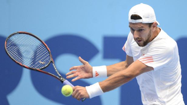 Ein Tennisspieler schlägt einen Ball mit seinem Schläger.