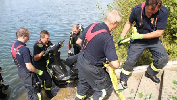 Feuerwehrleute bergen einen Jetski aus dem Wasser.