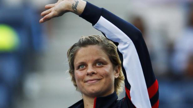 Kim Clijsters winkt mit einem Tattoo auf ihrem Handgelenk.