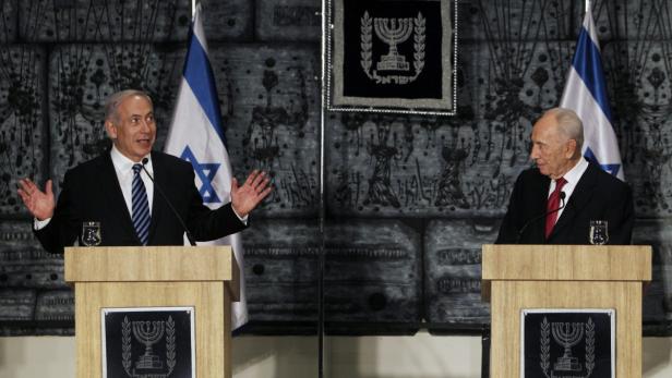 epa03630772 Israeli Prime Minister Benjamin Netanyahu (L) gestures as he speaks next to President Shimon Peres before a group photo with the ministers of the new Israeli parliament, in Jerusalem 18 March 2013. Netanyahu&#039;s new governing coalition took office after a parliamentary vote on Monday with powerful roles reserved for supporters of settlers in occupied territory. EPA/RONEN ZVULUN / POOL