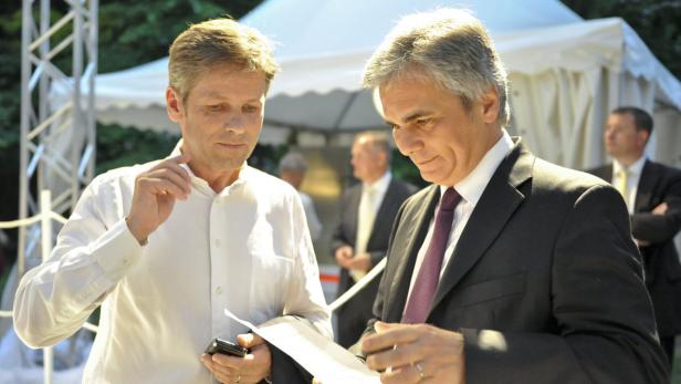 Zwei Männer in Anzügen betrachten ein Dokument im Freien.