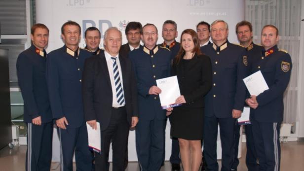 Eine Gruppe von Polizisten und Zivilpersonen posiert für ein Gruppenfoto.