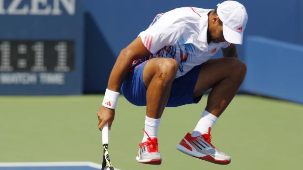 Ein Tennisspieler springt mit einem Tennisschläger auf einem Tennisplatz.