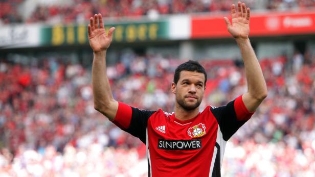 Ein Fußballspieler von Bayer Leverkusen winkt den Fans zu.