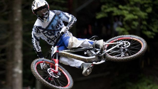 Ein Mountainbiker springt mit seinem Fahrrad in der Luft.