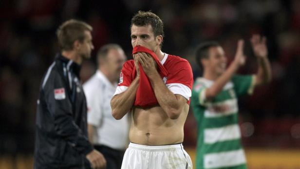 Ein Fußballspieler wischt sich mit einem roten Trikot den Schweiß ab.