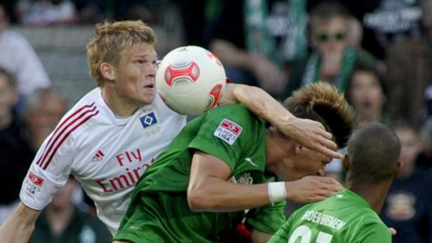 Ein Fußballspieler wird von einem Ball im Gesicht getroffen.