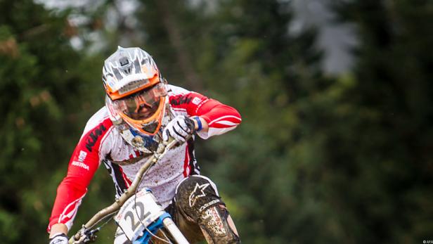 Ein Mountainbike-Fahrer mit der Nummer 22 fährt durch einen Wald.
