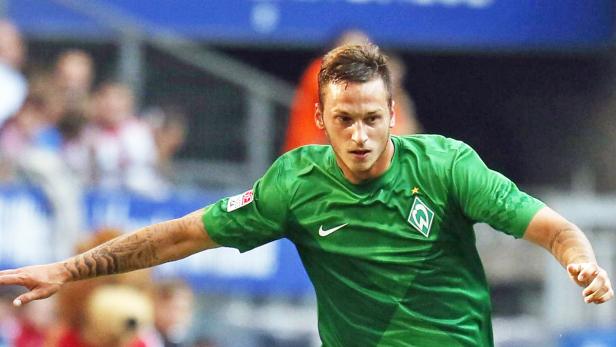 Ein Fußballspieler im grünen Trikot von Werder Bremen auf dem Spielfeld.