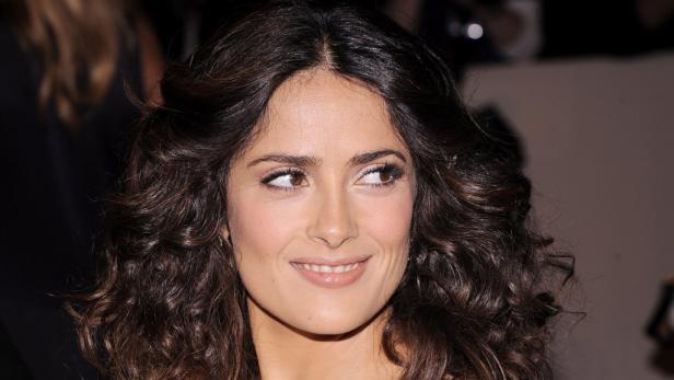 Salma Hayek lächelt mit lockigem, dunklem Haar.