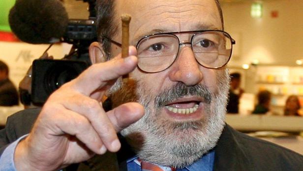 Ein Mann mit Brille hält einen kleinen Gegenstand in der Hand und spricht.