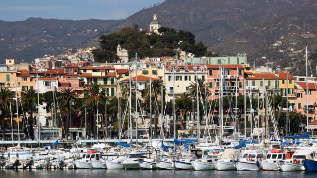 Blick auf den Hafen von Sanremo mit bunten Häusern und dem Hügel im Hintergrund.