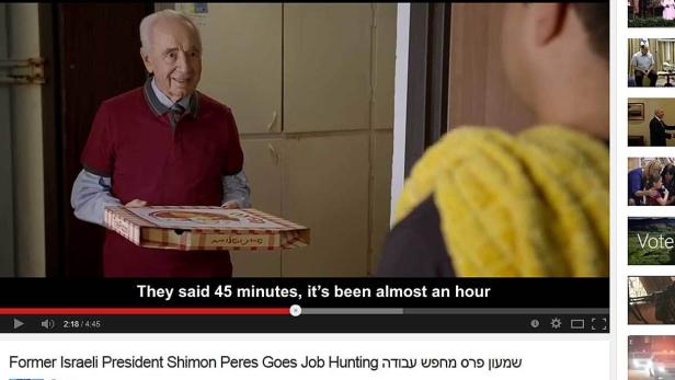 Der ehemalige israelische Präsident Shimon Peres hält eine Pizzaschachtel.