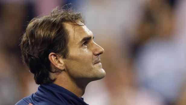 Roger Federer blickt auf einem Tennisplatz nach oben.