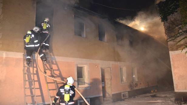 Feuerwehrleute bekämpfen einen Brand in einem mehrstöckigen Gebäude.