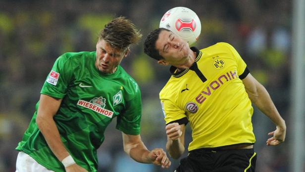 Zwei Fußballspieler kämpfen um den Ball mit ihren Köpfen.