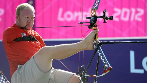 Ein behinderter Bogenschütze zielt mit dem Fuß auf seinen Bogen bei den Paralympics 2012 in London.