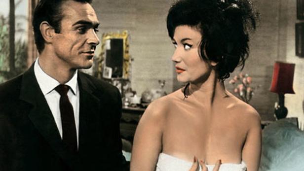 Sean Connery und eine Frau, in ein Handtuch gehüllt, in einer Szene aus dem Film „James Bond jagt Dr. No“.