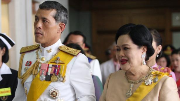 EPAepa01955431 Thi Queen Sirikit (R) is accompanied by his son Thai Crown Prince Maha Vajiralongkorn (L) leave Siriraj hospital to Grand Palace for the royal ceremony marking King Bhumibol Adulyadejs 82nd birthday in Bangkok, Thailand, 05 December 2009. K Der thailändische König und seine Frau Sirikit in formeller Kleidung.
