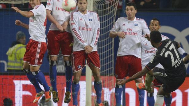 Fußballspieler des Hamburger SV springen bei einem Spiel in die Luft.