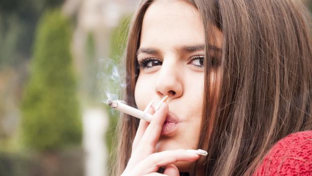 Ein junges Mädchen raucht eine Zigarette